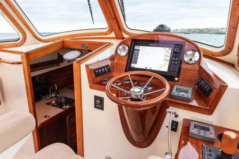 Slide: The Image of 2004 Hinckley Picnic Boat EP helm with wooden finish and modern navigation system. - 13