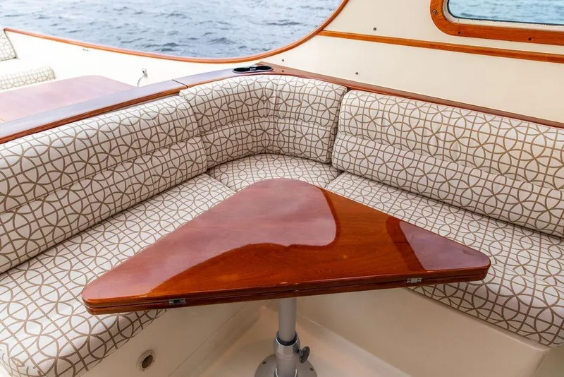 Slide: The Image of 2004 Hinckley Picnic Boat EP interior with patterned seating and polished wooden table. - 16