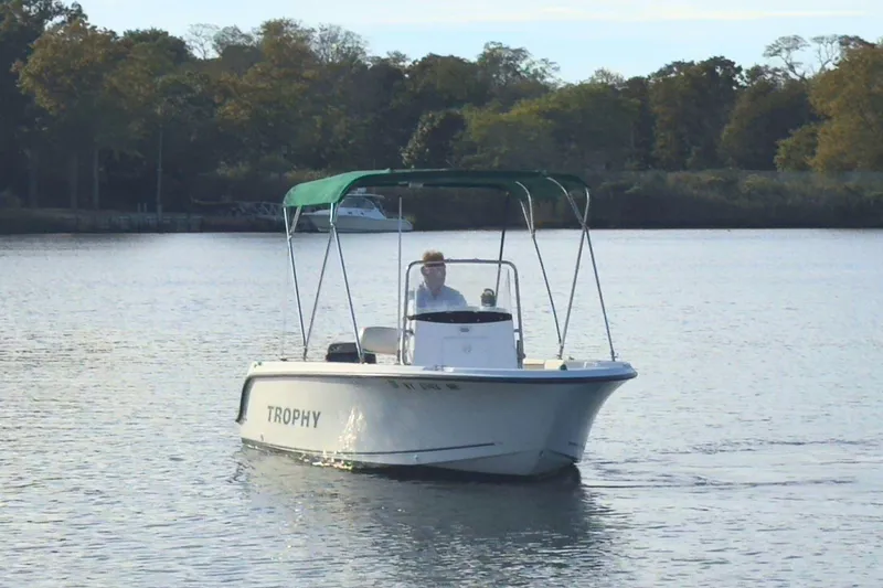 The Image of 2008 Trophy 1703 Center Console boat cruising on a calm lake with trees in the background. - 0