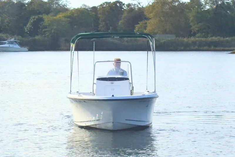 Slide: The Image of 2008 Trophy 1703 Center Console boat on calm water with green canopy. - 2
