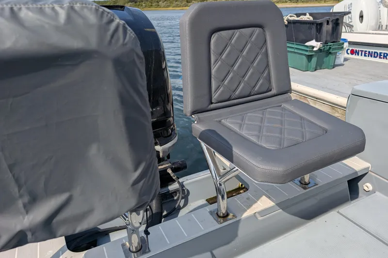 Slide: The Image of 2019 Axopar 28 CABIN boat seat with diamond-stitched upholstery, docked by the water. - 10
