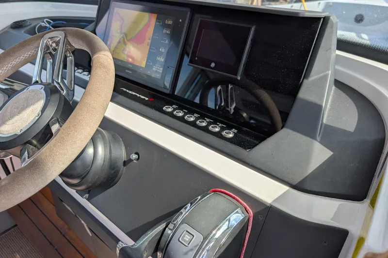 Slide: The Image of 2019 Axopar 28 CABIN dashboard with steering wheel and navigation display. - 21