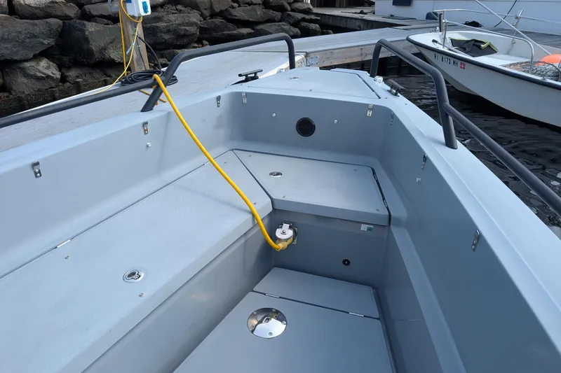 Slide: The Image of 2019 Axopar 28 CABIN boat interior with seating and yellow cable on dock. - 12