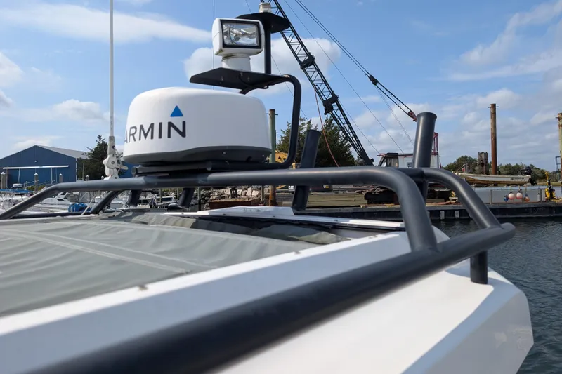 Slide: The Image of 2019 Axopar 28 CABIN with Garmin radar, docked near industrial equipment. - 4