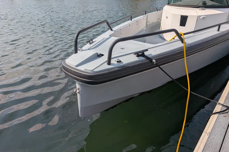 Slide: The Image of 2019 Axopar 28 CABIN boat docked on calm water. - 9