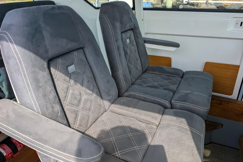Slide: The Image of 2019 Axopar 28 CABIN interior with plush gray seating and armrests. - 19