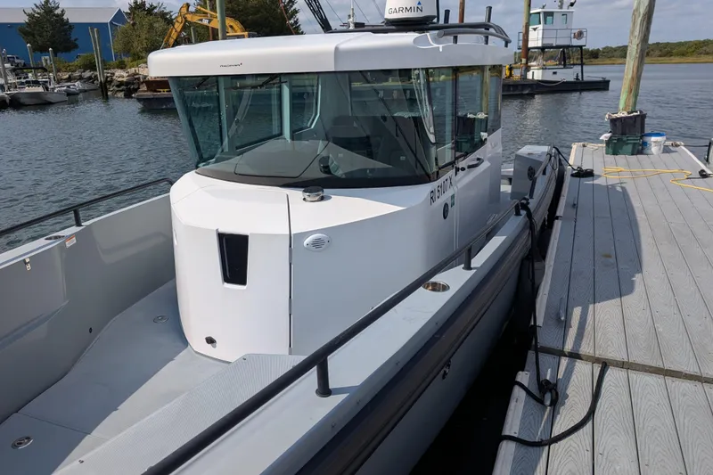 Slide: The Image of 2019 Axopar 28 CABIN boat docked at a marina, featuring sleek design and modern cabin. - 8