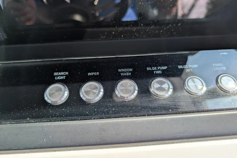 Slide: The Image of Control panel of 2019 Axopar 28 CABIN boat with labeled buttons for various functions. - 27