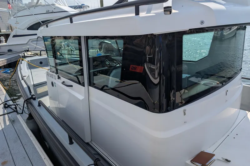 Slide: The Image of 2019 Axopar 28 CABIN boat docked at marina, showcasing sleek design and modern features. - 56