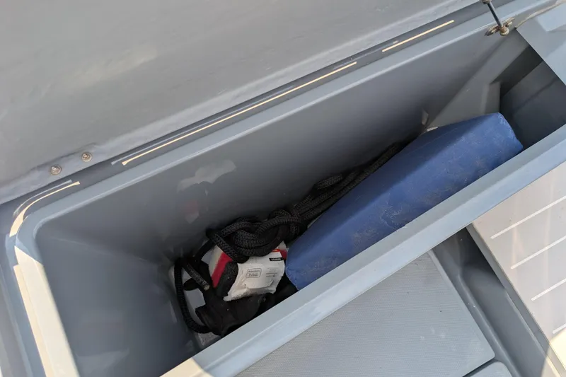 Slide: The Image of Storage compartment in 2019 Axopar 28 CABIN boat with rope and cushion. - 60