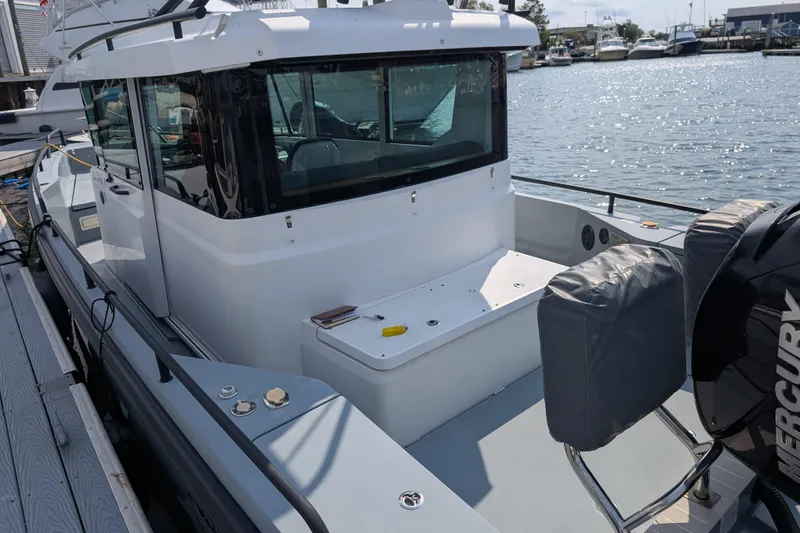 Slide: The Image of 2019 Axopar 28 CABIN boat docked, featuring sleek design and Mercury engine. - 45
