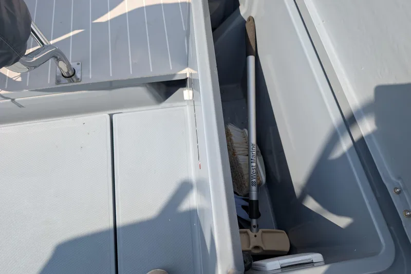 Slide: The Image of Storage compartment on 2019 Axopar 28 CABIN boat with cleaning brush inside. - 44