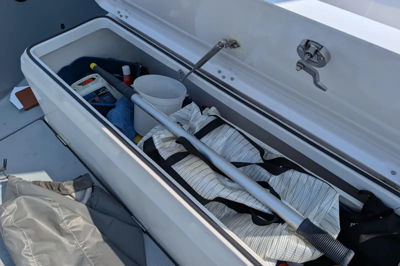Slide: The Image of Storage compartment of 2019 Axopar 28 CABIN boat with various boating equipment. - 16