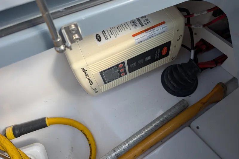 Slide: The Image of Battery charger in 2019 Axopar 28 CABIN boat compartment with cables and tools. - 18