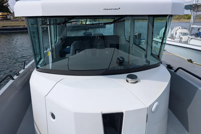 Slide: The Image of 2019 Axopar 28 CABIN boat with sleek design, docked on calm water. - 40