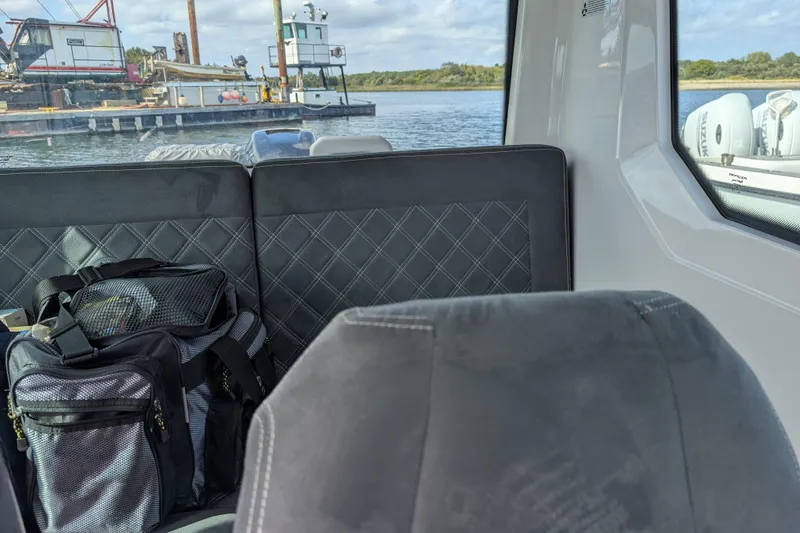 Slide: The Image of Interior of 2019 Axopar 28 CABIN with quilted seats and a bag, near a dock. - 34