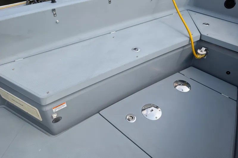Slide: The Image of 2019 Axopar 28 CABIN boat deck with storage compartments and yellow cable. - 11