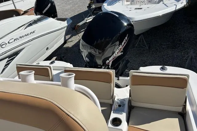 Slide: The Image of 2023 Nautistar 227XTS boat with Mercury engine, docked alongside other boats. - 7