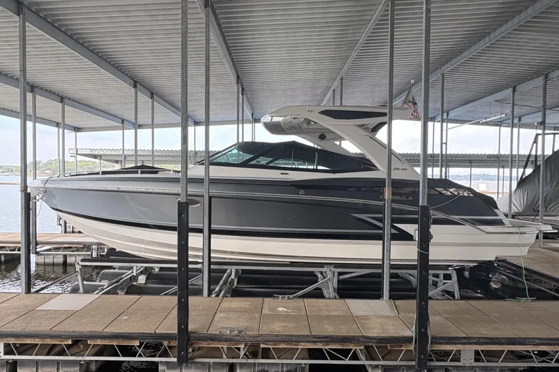 The Image of 2021 Formula 330 Crossover Bowrider I/O docked under a covered marina. - 0