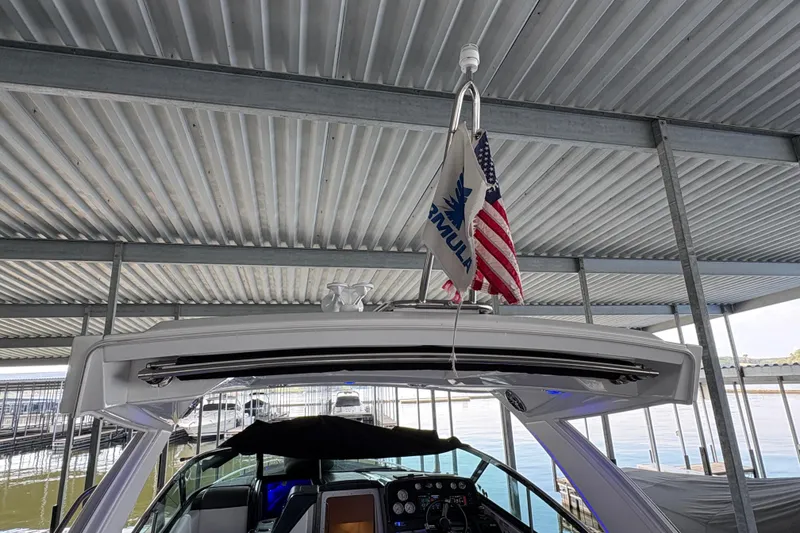 Slide: The Image of 2021 Formula 330 Crossover Bowrider I/O docked, covered with black canvas. - 18