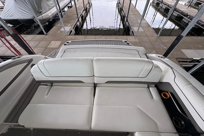 Slide: The Image of 2021 Formula 330 Crossover Bowrider I/O interior seating with white upholstery and cup holders. - 24