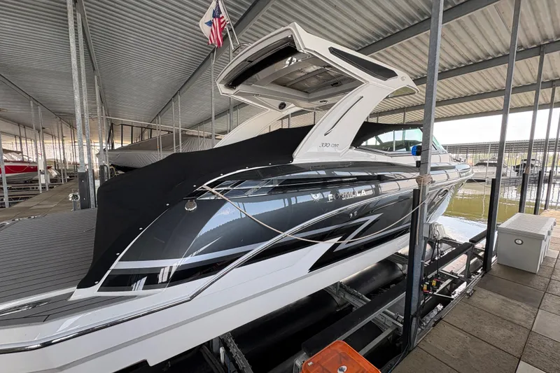 Slide: The Image of 2021 Formula 330 Crossover Bowrider I/O docked under a covered marina. - 3