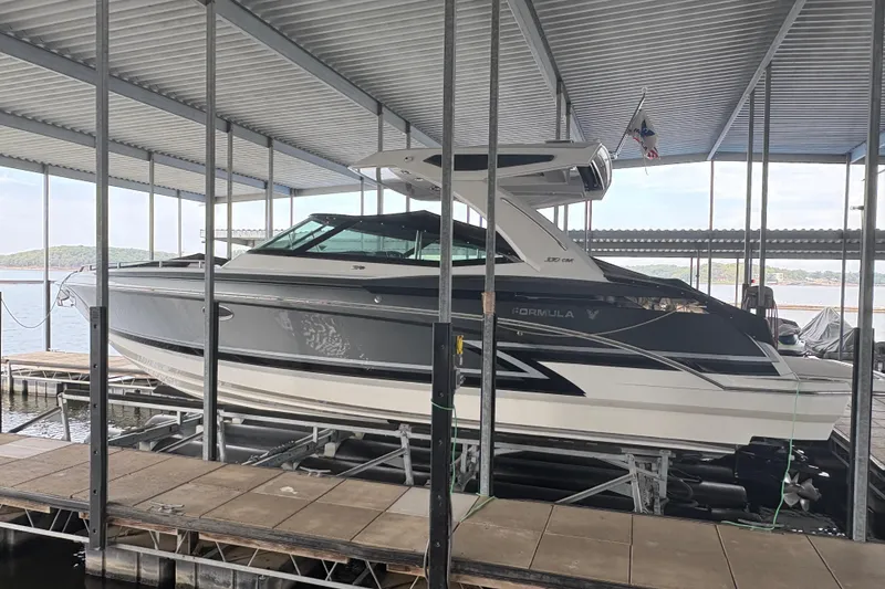 Slide: The Image of 2021 Formula 330 Crossover Bowrider I/O docked under a covered marina. - 4