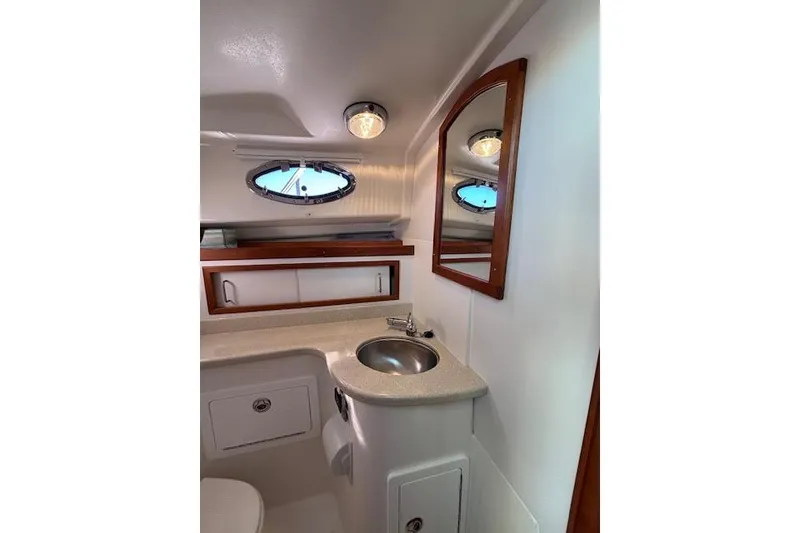 Slide: The Image of 2018 Back Cove 30 yacht bathroom with sink, mirror, and porthole window. - 35