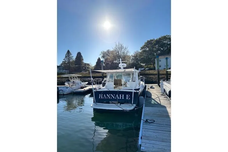 Slide: The Image of 2018 Back Cove 30 boat docked under clear sky, named "HANNAH E". - 6