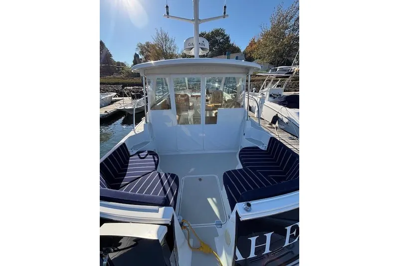 Slide: The Image of 2018 Back Cove 30 boat with striped seating, docked under sunny skies. - 9