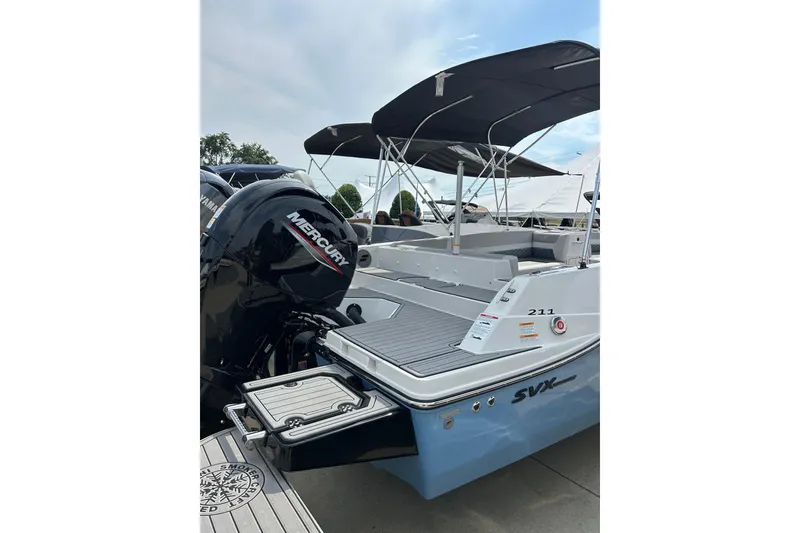 Slide: The Image of 2026 Starcraft SVX 211 OB boat with Mercury outboard motor, docked under a clear sky. - 4