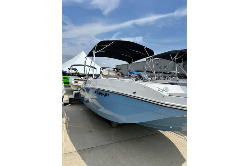 Slide: The Image of 2026 Starcraft SVX 211 OB boat with canopy, displayed outdoors under a blue sky. - 5