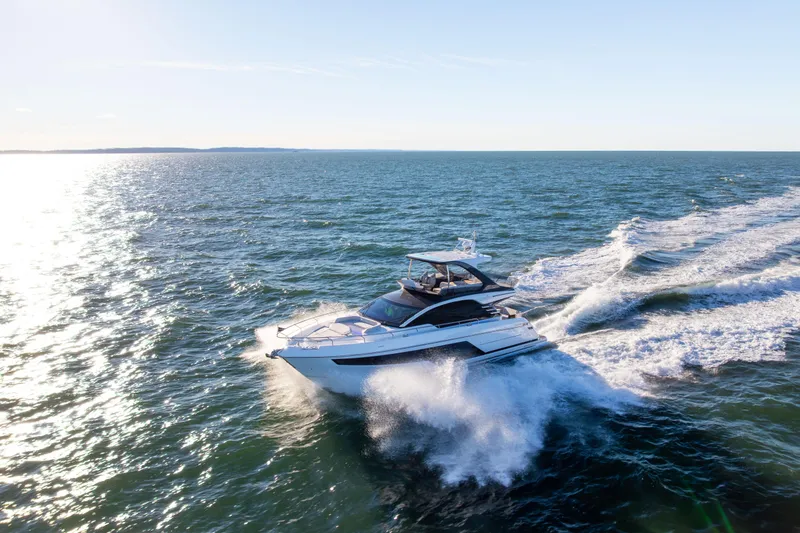 Slide: The Image of 2025 Fairline Squadron 58 yacht cruising on open sea under clear blue sky. - 104