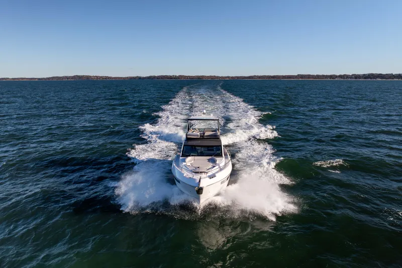 Slide: The Image of 2025 Fairline Squadron 58 yacht cruising on open water under clear blue skies. - 105