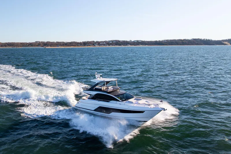 Slide: The Image of 2025 Fairline Squadron 58 yacht cruising on open water. - 106
