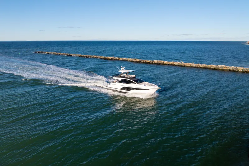 Slide: The Image of 2025 Fairline Squadron 58 yacht cruising on open sea under clear blue sky. - 110