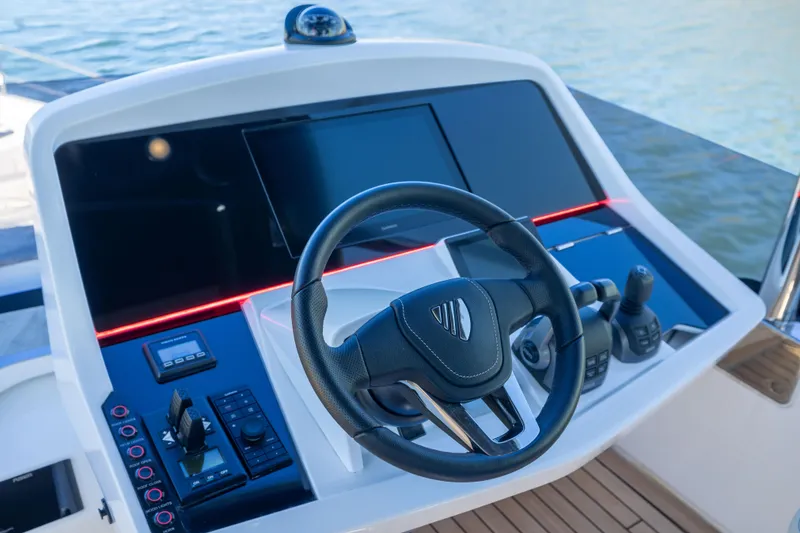 Slide: The Image of Helm of 2025 Fairline Squadron 58 yacht with modern controls and steering wheel. - 80