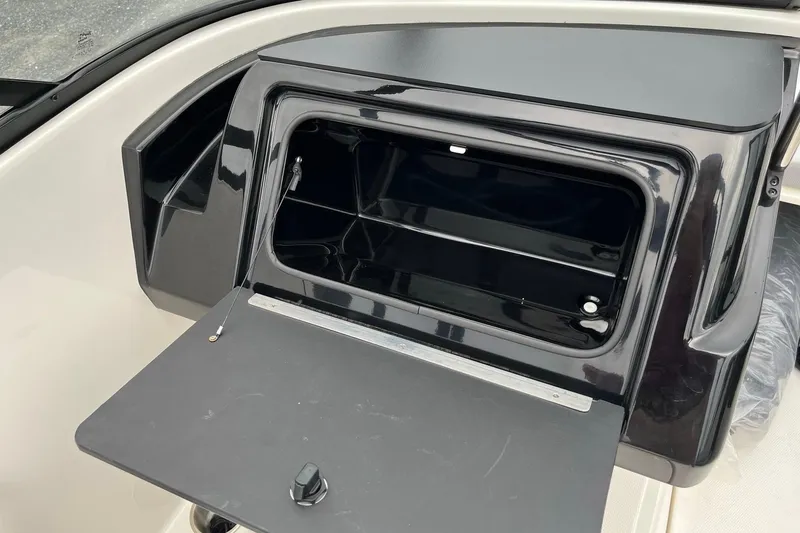 Slide: The Image of 2026 Bayliner V20 boat storage compartment with open hatch, showcasing sleek black interior design. - 16