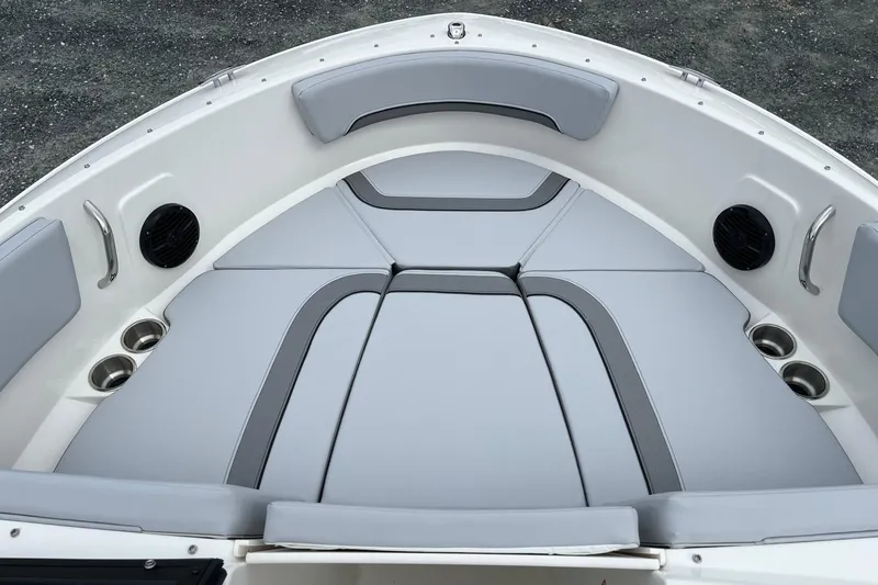 Slide: The Image of 2026 Bayliner V20 boat interior with gray cushioned seating and cup holders. - 18