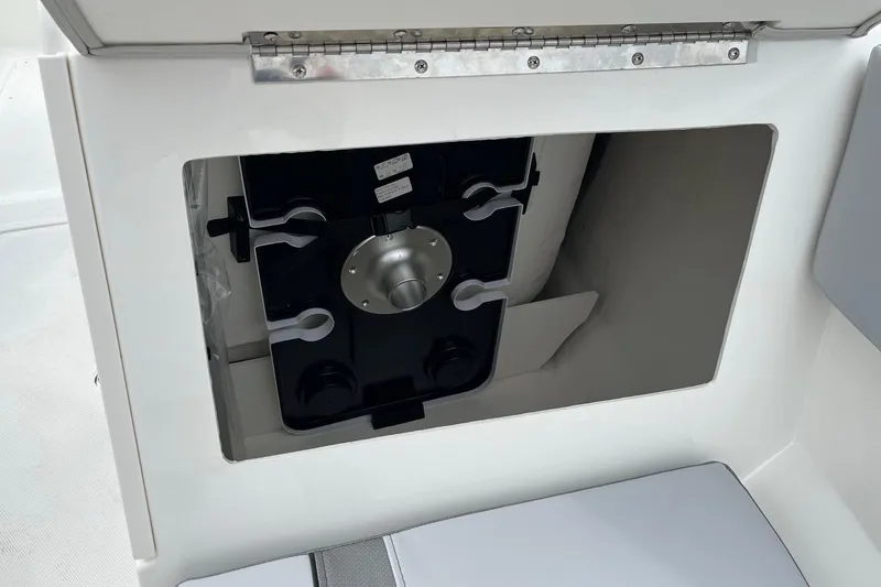 Slide: The Image of 2026 Bayliner V20 boat storage compartment with secure latch and organized interior. - 21