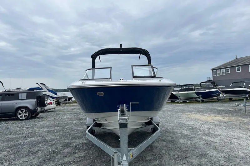 Slide: The Image of 2026 Bayliner V20 boat on trailer, parked outdoors under cloudy sky. - 6