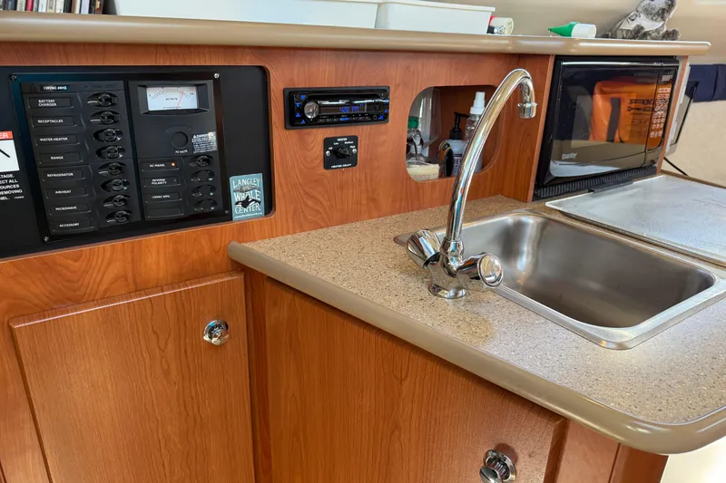 Slide: The Image of 2006 Bayliner 245 Cruiser interior with sink, control panel, and microwave. - 10