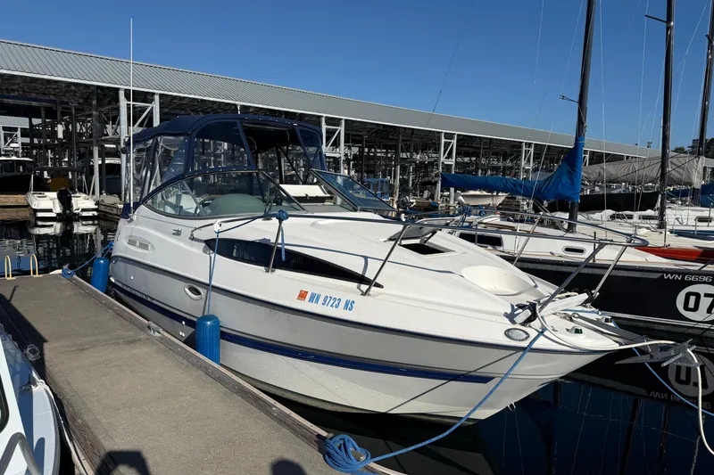 Slide: The Image of 2006 Bayliner 245 Cruiser docked at marina, featuring sleek design and blue accents. - 15