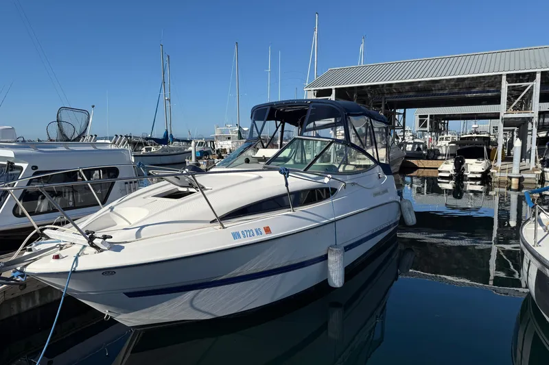 Slide: The Image of 2006 Bayliner 245 Cruiser docked at marina, surrounded by other boats. - 16