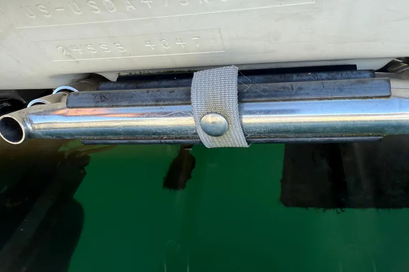 Slide: The Image of Exhaust pipe of a 2006 Bayliner 245 Cruiser above green water. - 4