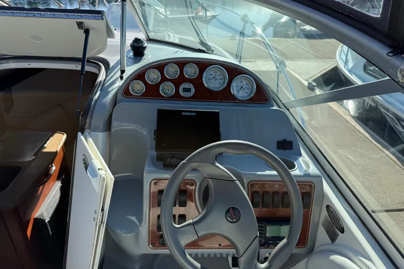 Slide: The Image of 2006 Bayliner 245 Cruiser helm with gauges and steering wheel. - 7