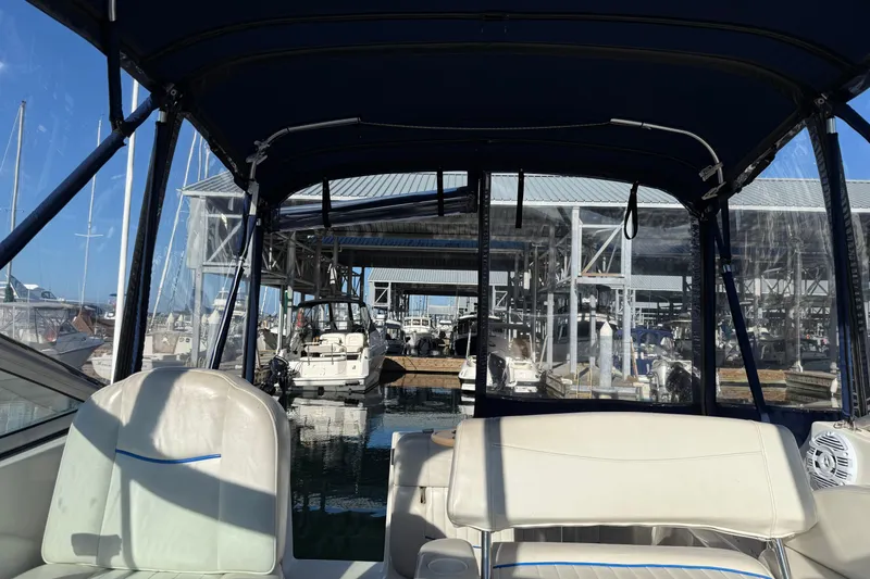Slide: The Image of 2006 Bayliner 245 Cruiser interior view at marina with boats and covered dock. - 9