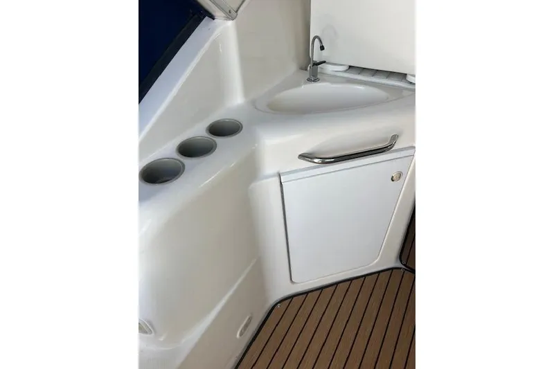 Slide: The Image of 1999 Bayliner 3055 Ciera Sunbridge boat interior with sink and cup holders. - 13