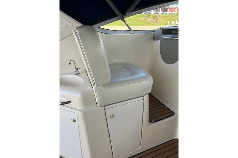 Slide: The Image of 1999 Bayliner 3055 Ciera Sunbridge interior with white seat and compact sink. - 14