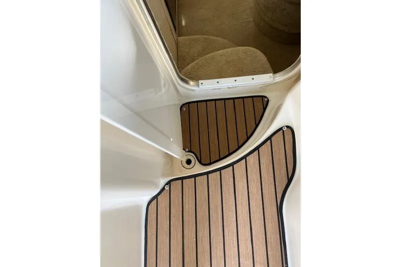 Slide: The Image of 1999 Bayliner 3055 Ciera Sunbridge interior with teak-style flooring and carpeted steps. - 15